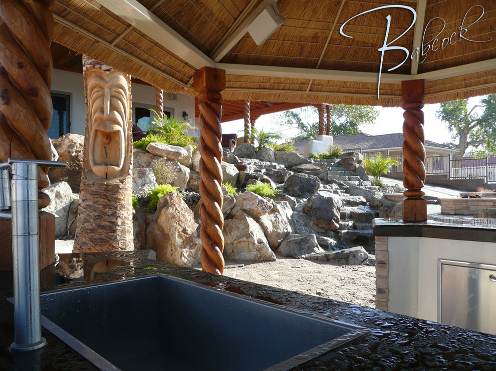 Inspiration for a mid-sized tropical natural backyard stone, custom-shaped and brick exterior home remodel