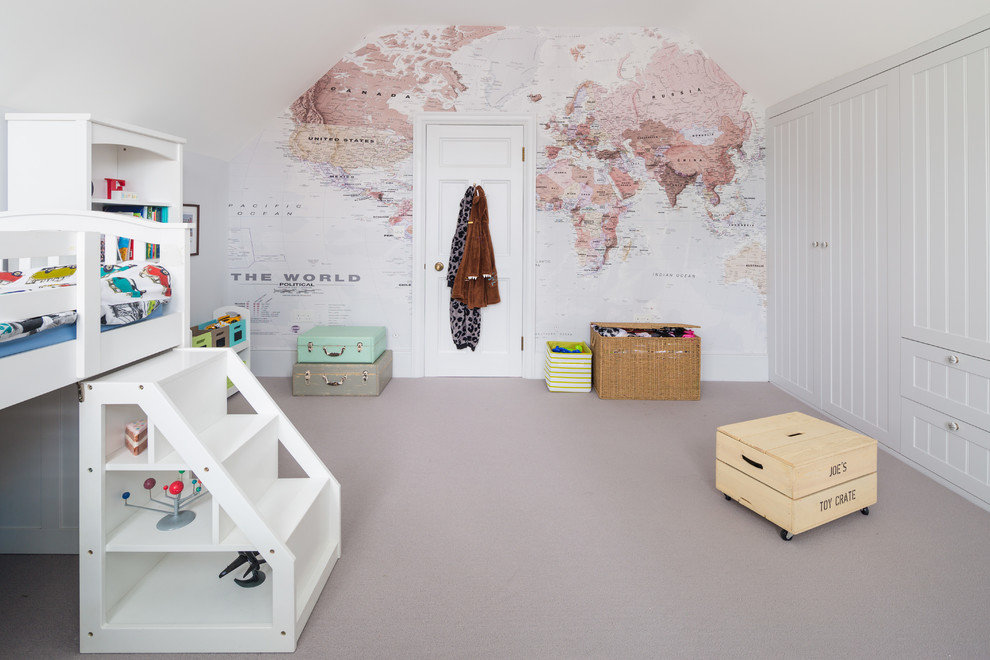 Photo of a mid-sized transitional toddler room for boys in London with carpet, white walls and grey floor.