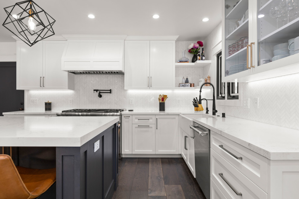 Large minimalist u-shaped dark wood floor and brown floor eat-in kitchen photo in Los Angeles with a farmhouse sink, shaker cabinets, white cabinets, quartz countertops, white backsplash, marble backsplash, stainless steel appliances and white countertops