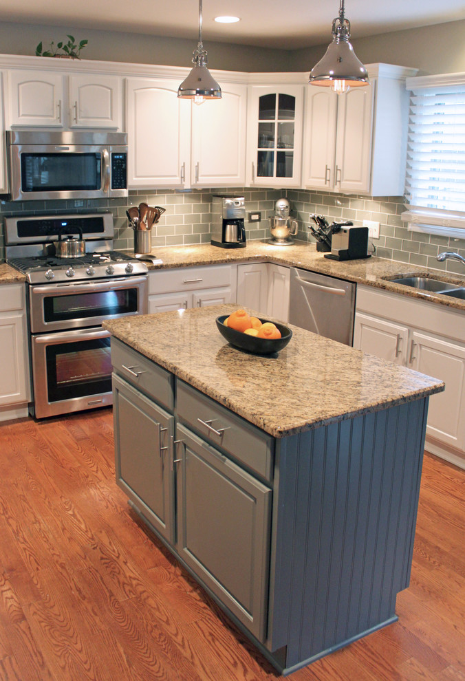 Eat-in kitchen - mid-sized transitional u-shaped medium tone wood floor eat-in kitchen idea in Chicago with an undermount sink, recessed-panel cabinets, white cabinets, granite countertops, gray backsplash, glass tile backsplash, stainless steel appliances and an island