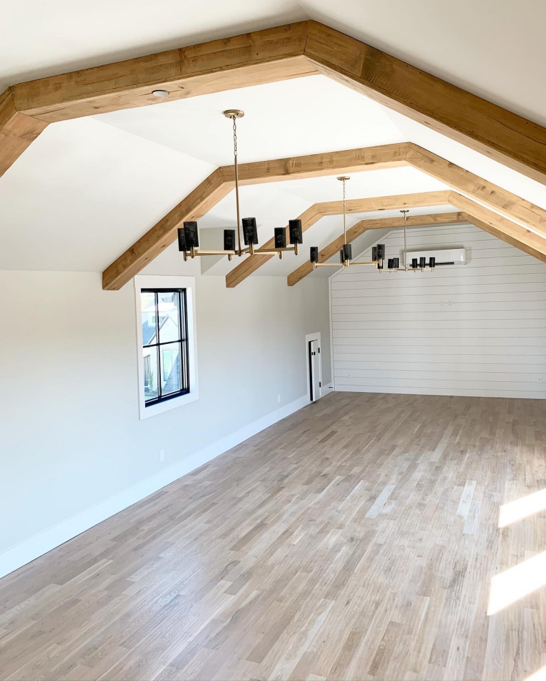 Photo of a large country home yoga studio in Dallas with white walls, light hardwood floors, brown floor and exposed beam.