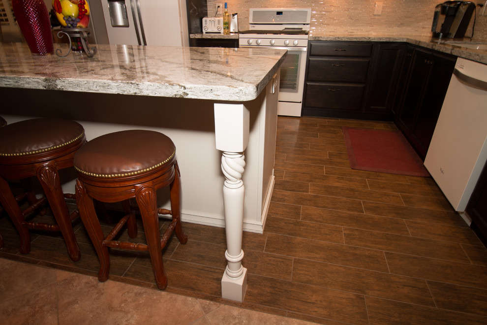 Mid-sized transitional l-shaped porcelain tile open concept kitchen photo with an undermount sink, flat-panel cabinets, dark wood cabinets, quartz countertops, beige backsplash, glass sheet backsplash, white appliances and an island