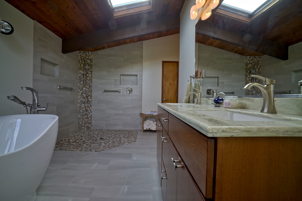 Inspiration for a large contemporary master bathroom in DC Metro with a corner shower, porcelain floors, flat-panel cabinets, medium wood cabinets, a freestanding tub, multi-coloured tile, pebble tile, white walls, a trough sink and granite benchtops.