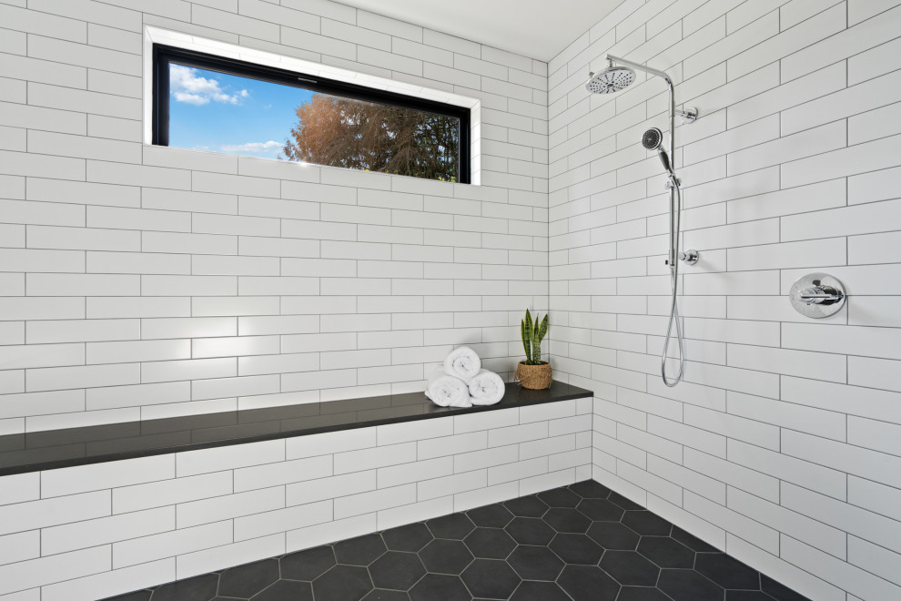 Inredning av ett lantligt stort grå grått badrum med dusch, med skåp i shakerstil, en kantlös dusch, en toalettstol med hel cisternkåpa, vit kakel, tunnelbanekakel, vita väggar, klinkergolv i keramik, ett undermonterad handfat, bänkskiva i kvartsit, med dusch som är öppen, vita skåp och grått golv