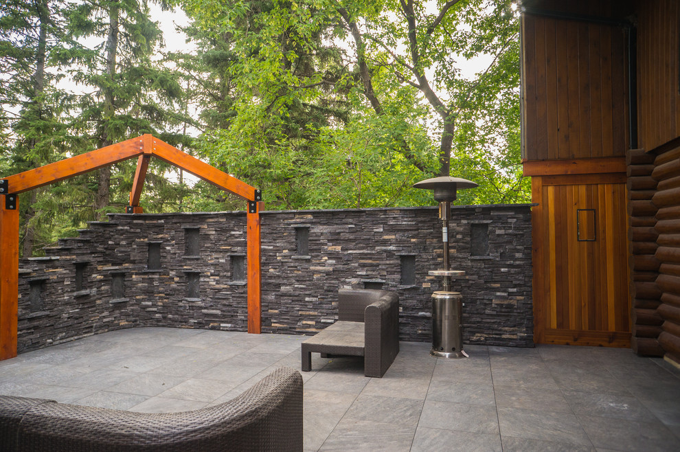 Example of a mountain style backyard deck design in Calgary