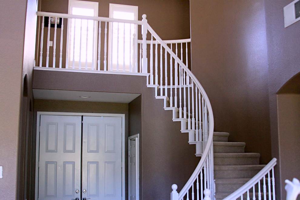 Inspiration for a mid-sized transitional carpeted curved staircase in San Diego with wood railing.