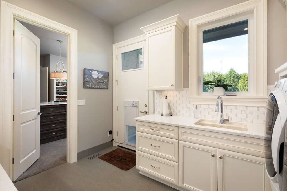 Mid-sized transitional galley utility room in Portland with an undermount sink, recessed-panel cabinets, white cabinets, quartz benchtops, grey walls, porcelain floors, grey floor and white benchtop.