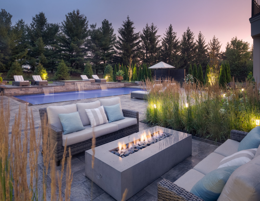 Pool landscaping - large transitional backyard brick and rectangular lap pool landscaping idea in Toronto