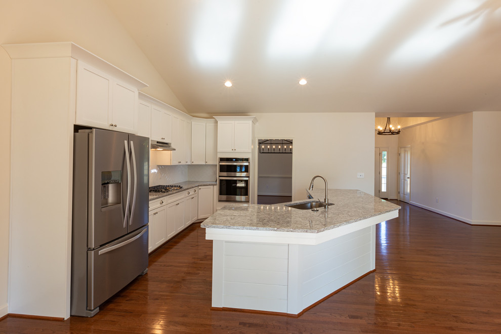 Mid-sized transitional dark wood floor and brown floor kitchen photo in DC Metro with an undermount sink, flat-panel cabinets, white cabinets, granite countertops, white backsplash, ceramic backsplash, stainless steel appliances, an island and gray countertops