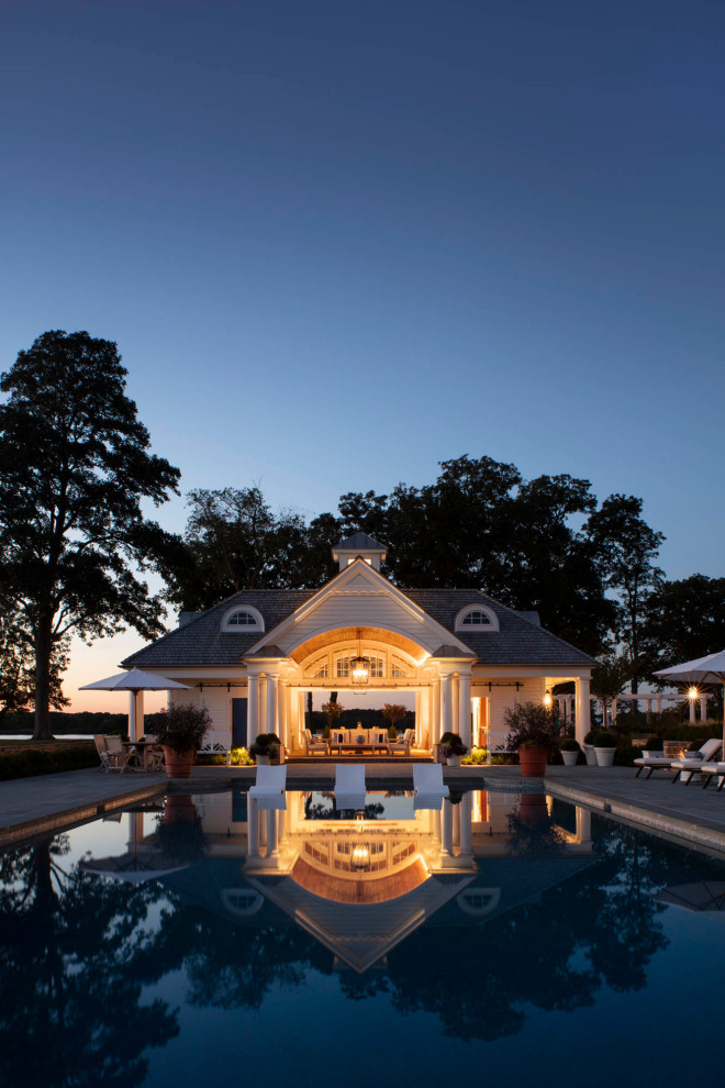 На фото: большой бассейн произвольной формы на заднем дворе в классическом стиле с домиком у бассейна и мощением тротуарной плиткой с