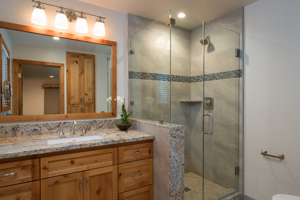 Corner shower - mid-sized rustic corner shower idea with recessed-panel cabinets, an undermount sink and granite countertops