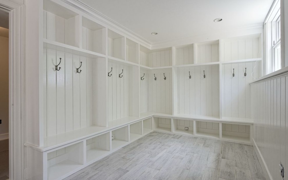 This is an example of a large country walk-in wardrobe in New York with white floor.