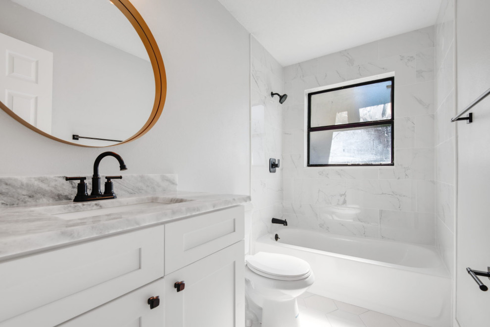 This is an example of a small traditional ensuite bathroom in Tampa with shaker cabinets, white cabinets, a built-in bath, a one-piece toilet, white tiles, ceramic tiles, white walls, ceramic flooring, a submerged sink, granite worktops, white floors, white worktops, a single sink and a built in vanity unit.