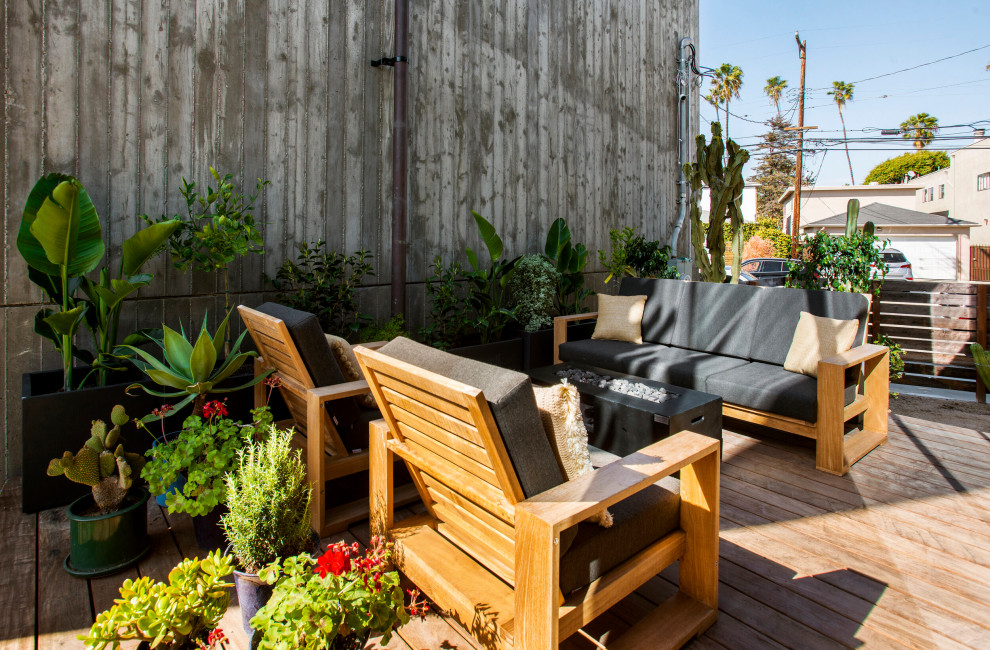 Photo of a medium sized industrial side ground level wood railing terrace in Los Angeles with no cover.