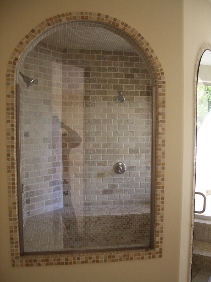 This is an example of a small mediterranean 3/4 bathroom in Los Angeles with raised-panel cabinets, dark wood cabinets, a drop-in tub, an alcove shower, a one-piece toilet, multi-coloured tile, stone tile, beige walls, travertine floors, a drop-in sink, concrete benchtops, multi-coloured floor, a hinged shower door and beige benchtops.