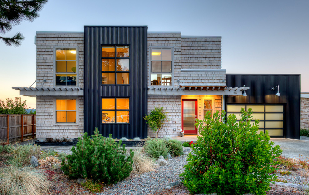 Mid-sized contemporary two-storey house exterior in Seattle with mixed siding, a flat roof and a metal roof.