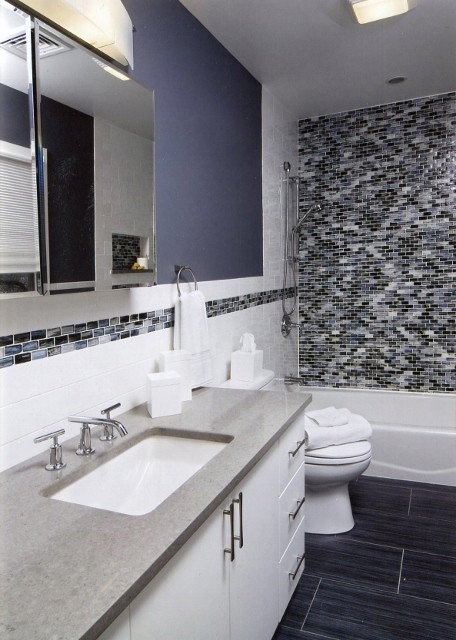 Design ideas for a mid-sized modern bathroom in New York with flat-panel cabinets, white cabinets, an alcove tub, a shower/bathtub combo, a two-piece toilet, black tile, multi-coloured tile, white tile, matchstick tile, purple walls, an undermount sink and granite benchtops.