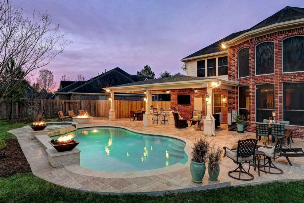 Mid-sized traditional backyard patio in Houston with an outdoor kitchen, tile and a roof extension.