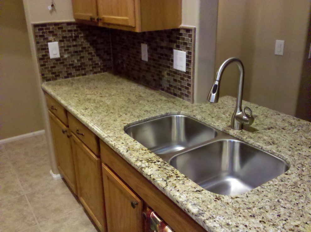 Example of a ceramic tile kitchen design in Phoenix with a double-bowl sink, light wood cabinets, granite countertops, multicolored backsplash, mosaic tile backsplash and stainless steel appliances