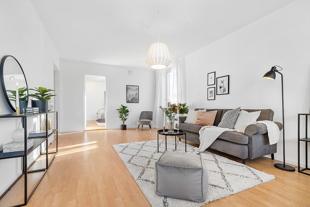 Klassisk inredning av ett mellanstort separat vardagsrum, med vita väggar, ljust trägolv och beiget golv