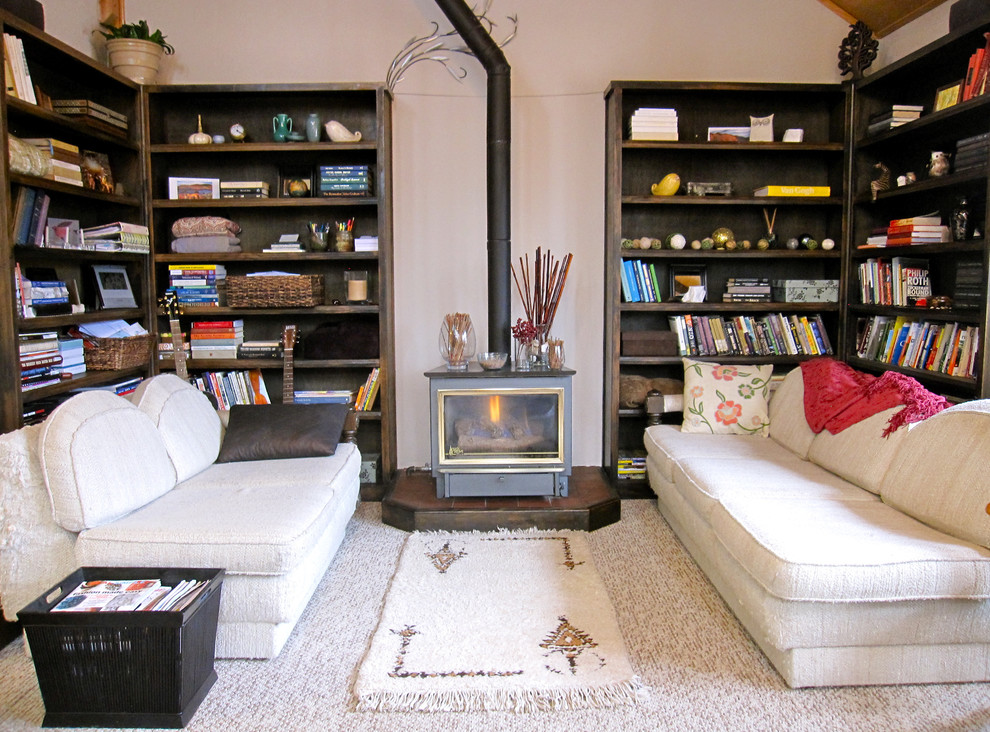 This is an example of an eclectic living room in Denver with white walls and a wood stove.