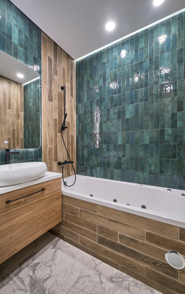 This is an example of a mid-sized contemporary master wet room bathroom in Moscow with flat-panel cabinets, medium wood cabinets, a hot tub, a wall-mount toilet, green tile, ceramic tile, green walls, porcelain floors, a drop-in sink, solid surface benchtops, white floor, a sliding shower screen, white benchtops, a single vanity and a floating vanity.
