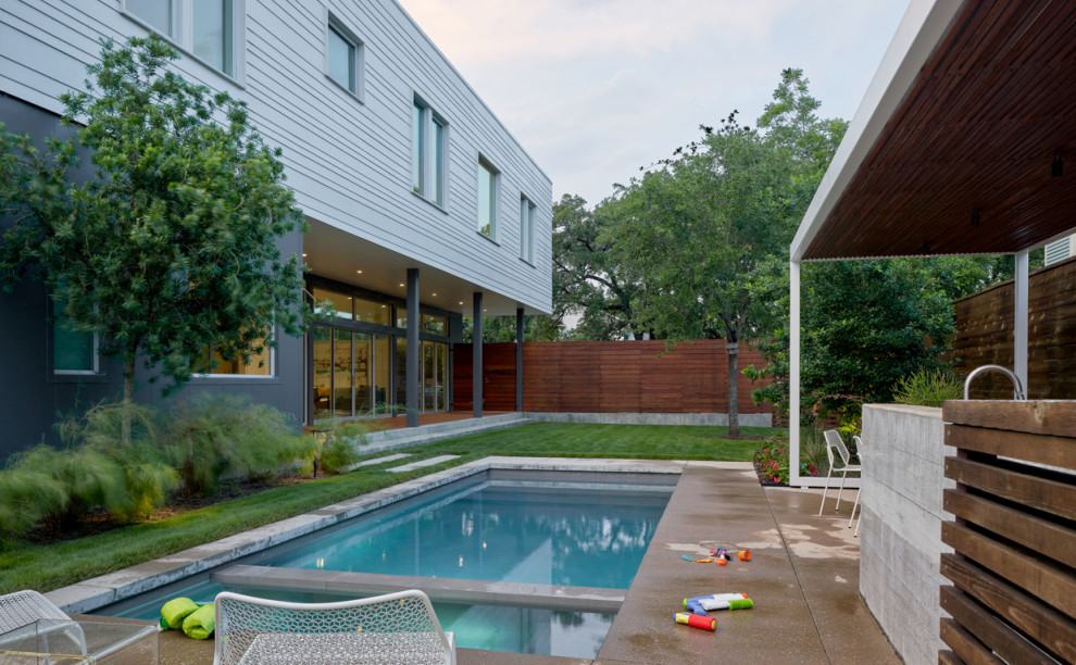 This is an example of a contemporary side yard pool in Houston.