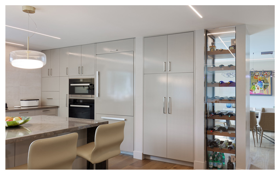 Large l-shaped eat-in kitchen photo with flat-panel cabinets and an island