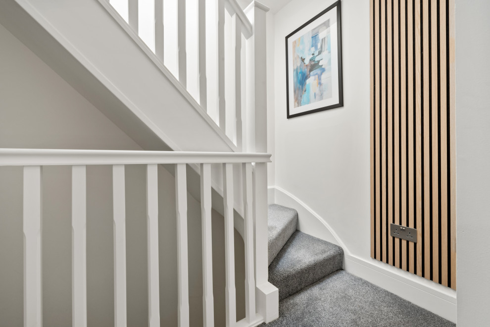 Idéer för att renovera en liten funkis svängd trappa, med heltäckningsmatta, sättsteg med heltäckningsmatta och räcke i trä