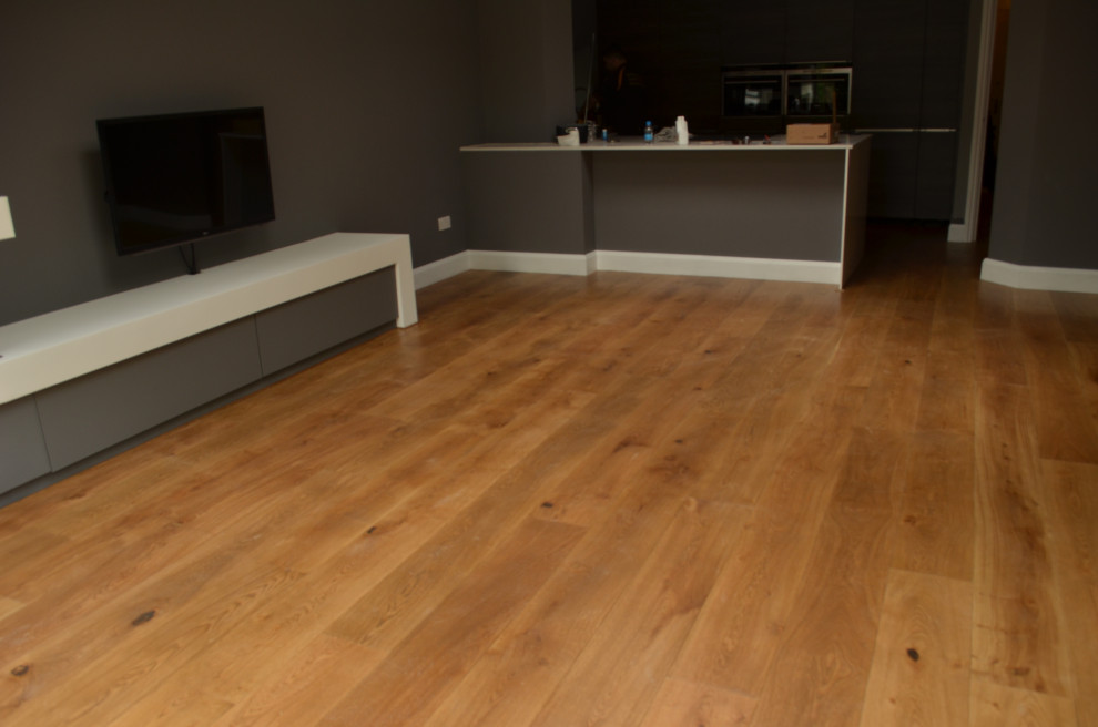 Modernes Wohnzimmer mit braunem Holzboden und braunem Boden in Surrey