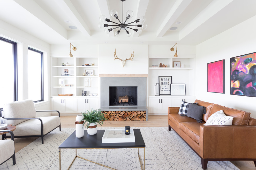 This is an example of a scandinavian formal enclosed living room in Boise with white walls, light hardwood floors, a standard fireplace, a concrete fireplace surround, no tv and brown floor.