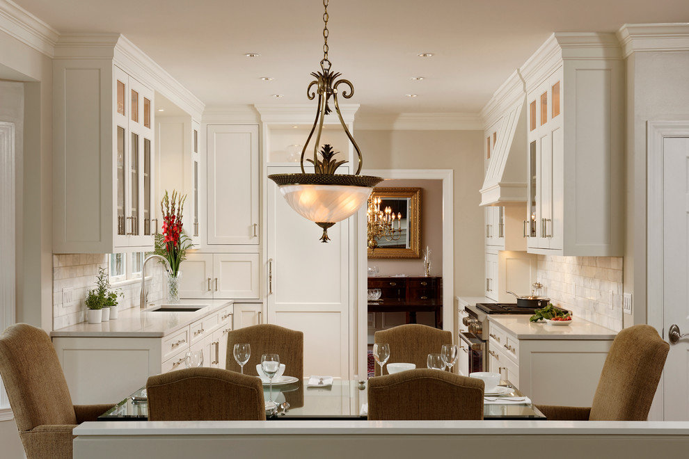 Design ideas for a small transitional u-shaped eat-in kitchen in DC Metro with white cabinets, no island, an undermount sink, panelled appliances, medium hardwood floors, recessed-panel cabinets, limestone benchtops, stone tile splashback, beige floor and white splashback.