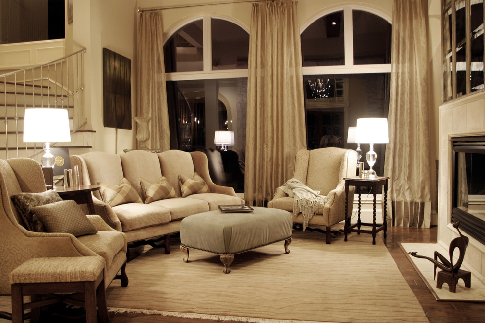 This is an example of a traditional living room in Houston with beige walls and a standard fireplace.