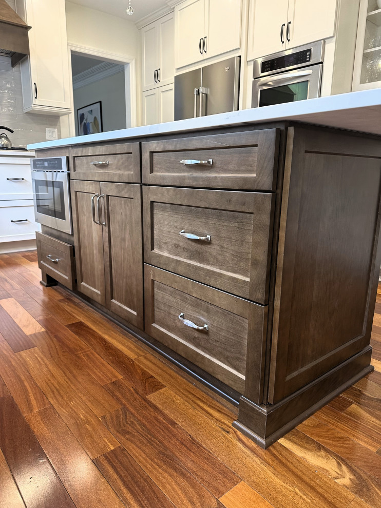 Eat-in kitchen - mid-sized transitional u-shaped medium tone wood floor and brown floor eat-in kitchen idea with an undermount sink, flat-panel cabinets, white cabinets, quartz countertops, beige backsplash, ceramic backsplash, stainless steel appliances, an island and white countertops