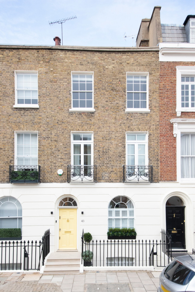 Photo of a large traditional brick white townhouse exterior in London with four or more storeys, a flat roof, a mixed roof and a black roof.