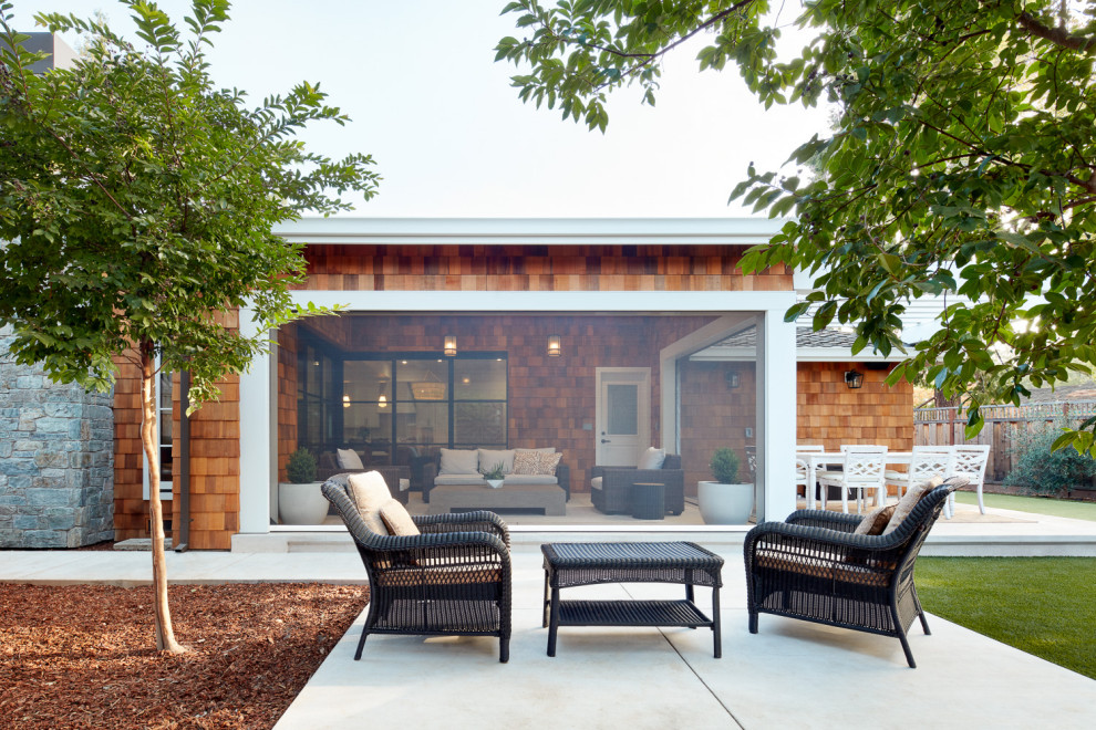 Example of a mid-sized transitional backyard stone patio design in San Francisco with a roof extension