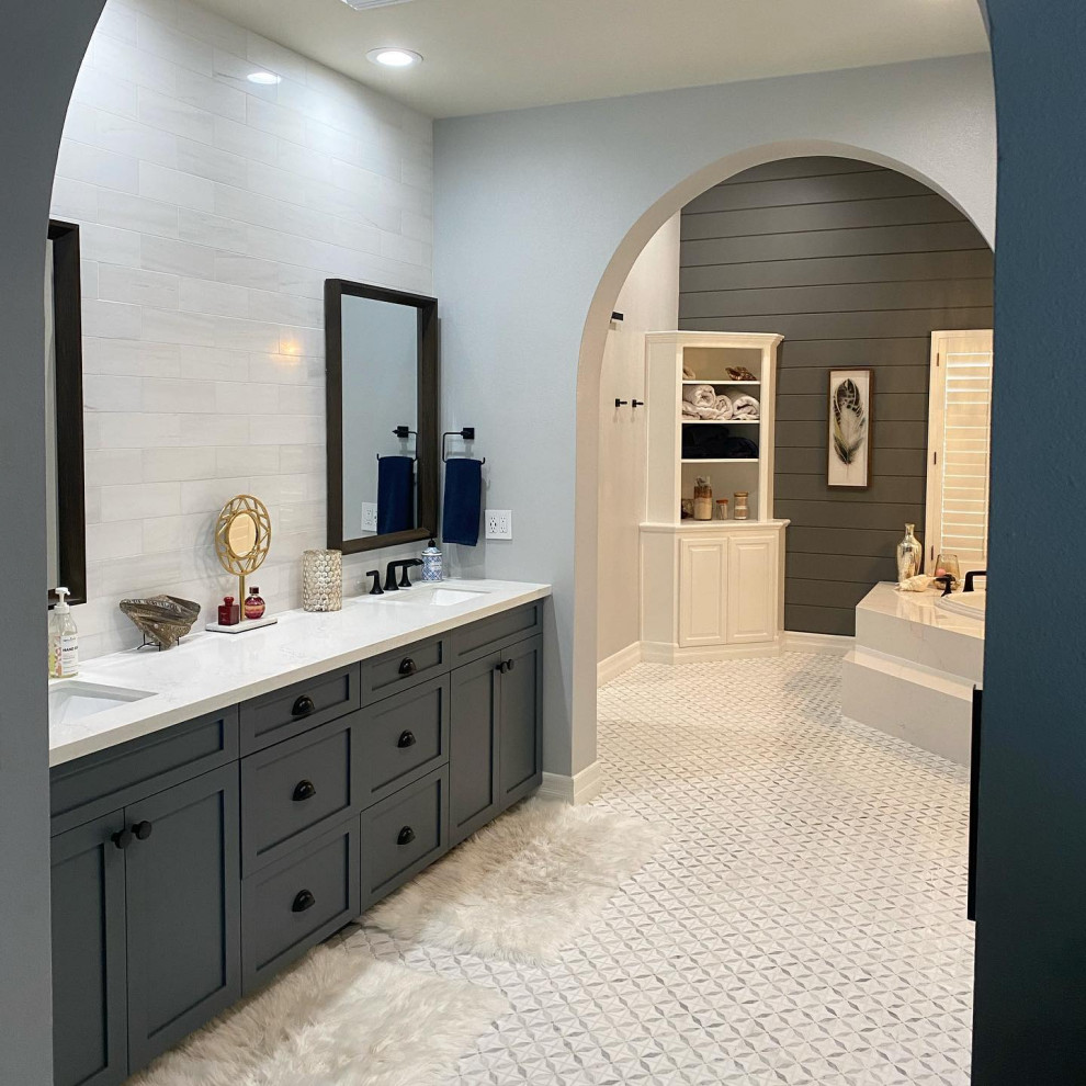 This is an example of an expansive traditional master bathroom in Orange County with shaker cabinets, grey cabinets, a corner tub, an alcove shower, a two-piece toilet, white tile, ceramic tile, grey walls, mosaic tile floors, an undermount sink, engineered quartz benchtops, multi-coloured floor, a hinged shower door, white benchtops, a double vanity, a built-in vanity and planked wall panelling.