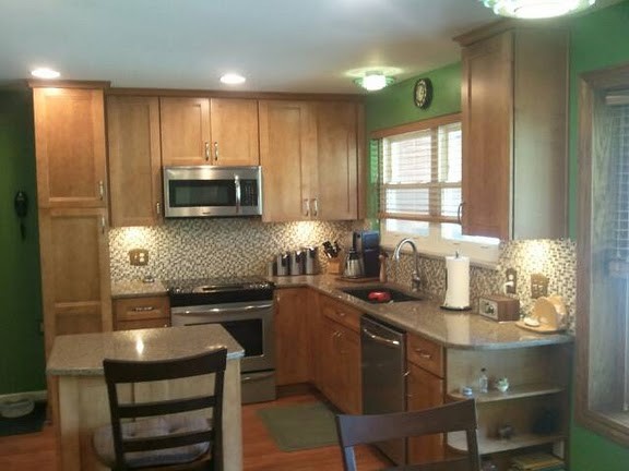 Example of a mid-sized transitional u-shaped medium tone wood floor eat-in kitchen design in Cincinnati with an undermount sink, flat-panel cabinets, medium tone wood cabinets, quartz countertops, multicolored backsplash, mosaic tile backsplash, stainless steel appliances and an island