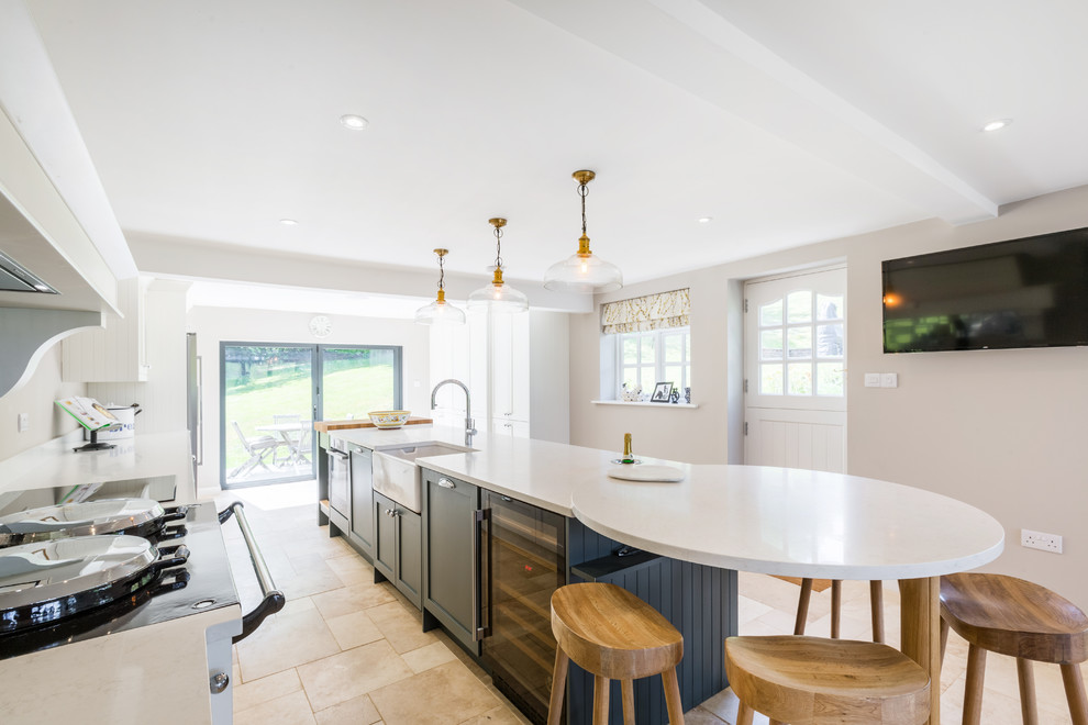 Design ideas for a large country single-wall open plan kitchen in Sussex with a farmhouse sink, quartzite benchtops, glass tile splashback, black appliances, with island and white benchtop.