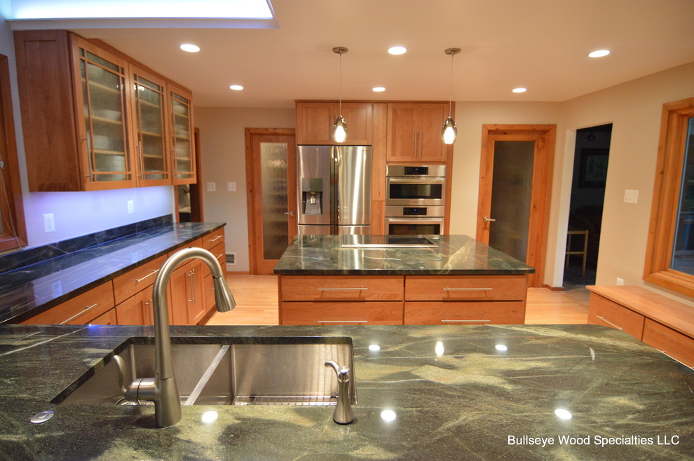 Eat-in kitchen - large transitional u-shaped light wood floor eat-in kitchen idea in DC Metro with a double-bowl sink, shaker cabinets, medium tone wood cabinets, granite countertops, green backsplash, stainless steel appliances and an island
