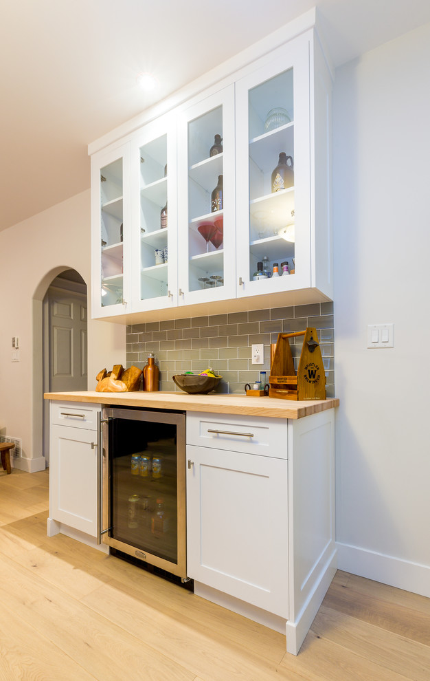 Inspiration for a large transitional u-shaped light wood floor open concept kitchen remodel with a farmhouse sink, shaker cabinets, blue cabinets, quartz countertops, gray backsplash, glass tile backsplash, stainless steel appliances, an island and white countertops