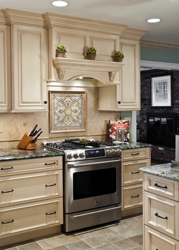 Eat-in kitchen - mid-sized traditional u-shaped ceramic tile eat-in kitchen idea in New York with an undermount sink, beige cabinets, granite countertops, beige backsplash, ceramic backsplash, stainless steel appliances, a peninsula and raised-panel cabinets