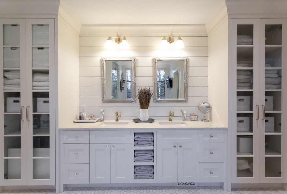Design ideas for a mid-sized traditional master bathroom in Calgary with shaker cabinets, white cabinets, a freestanding tub, an alcove shower, a two-piece toilet, white tile, porcelain tile, white walls, marble floors, an undermount sink, marble benchtops, grey floor, a hinged shower door, white benchtops, an enclosed toilet, a double vanity, a built-in vanity and planked wall panelling.