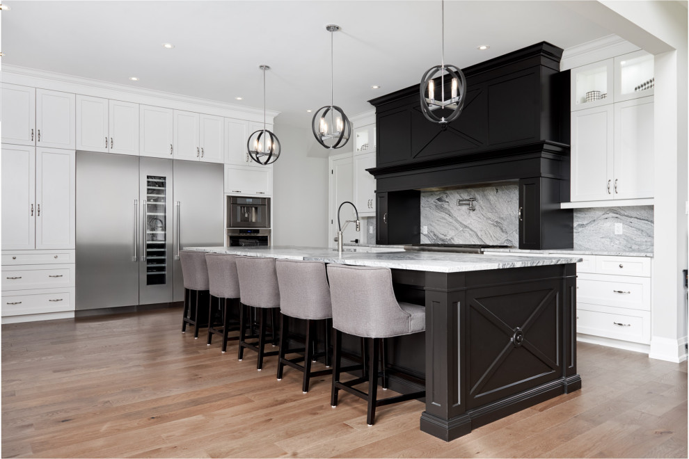 Eat-in kitchen - huge transitional light wood floor and brown floor eat-in kitchen idea in Toronto with a farmhouse sink, shaker cabinets, white cabinets, granite countertops, gray backsplash, granite backsplash, stainless steel appliances, an island and gray countertops