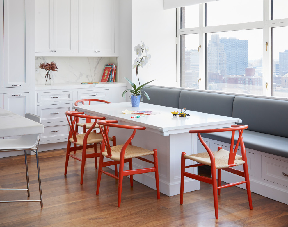 Example of a large transitional breakfast nook design with shaker cabinets, white cabinets, marble countertops, an island and white countertops