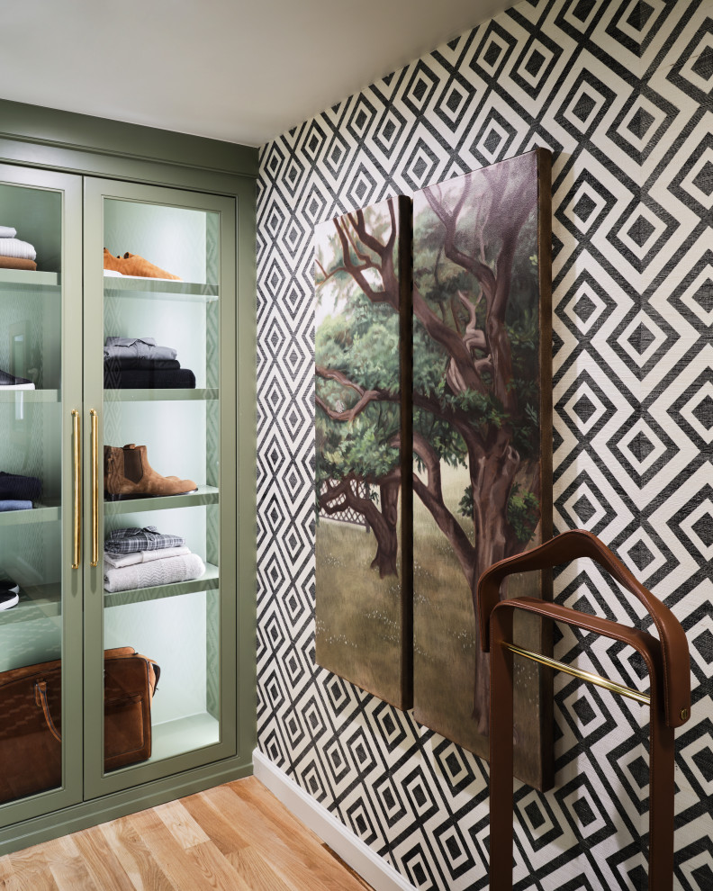 Klassisk inredning av ett litet walk-in-closet för män, med luckor med profilerade fronter, gröna skåp, ljust trägolv och beiget golv