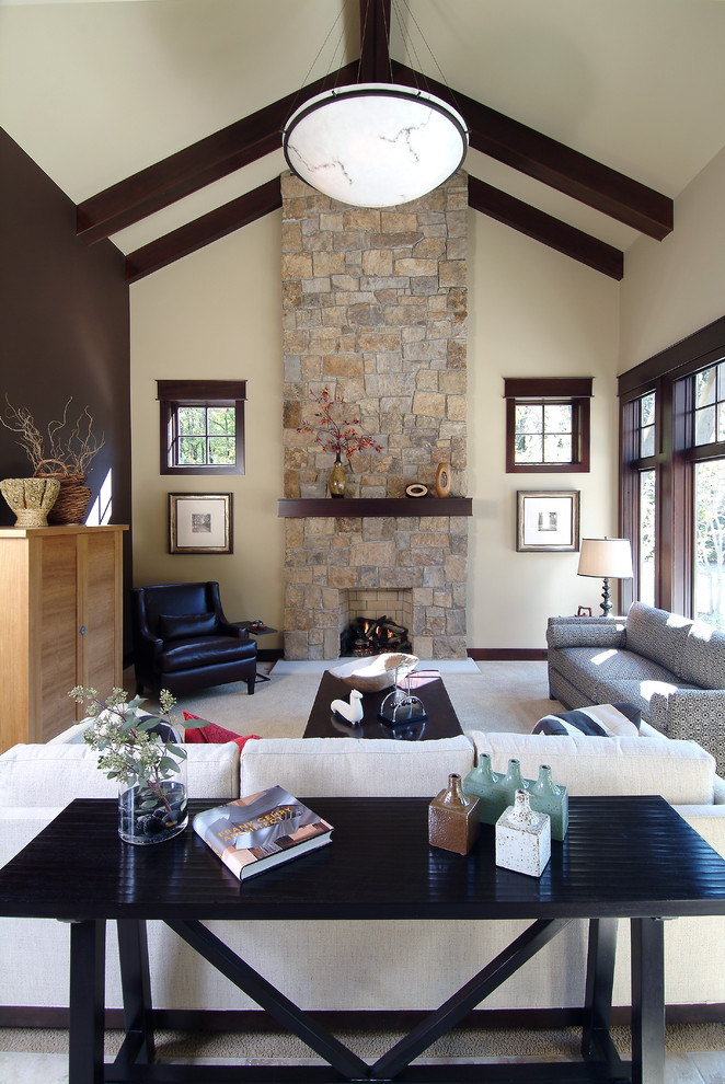 Small traditional open concept living room in Grand Rapids with a library, beige walls, light hardwood floors, a standard fireplace and a stone fireplace surround.
