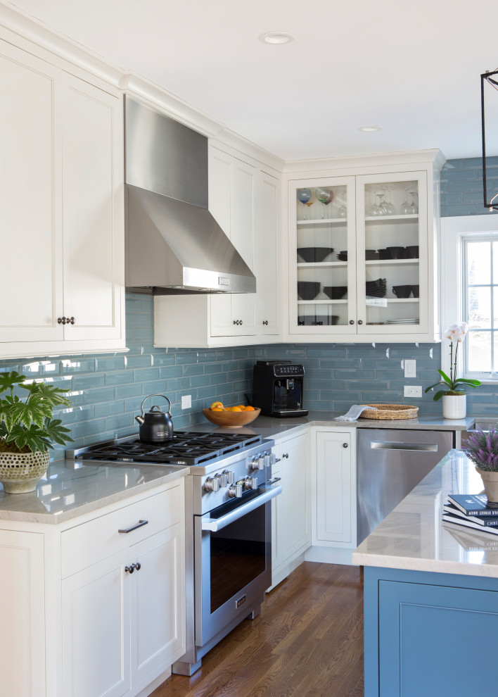 Modern inredning av ett mellanstort flerfärgad flerfärgat kök, med en rustik diskho, luckor med infälld panel, vita skåp, bänkskiva i kvartsit, blått stänkskydd, stänkskydd i glaskakel, rostfria vitvaror, mellanmörkt trägolv, en köksö och brunt golv