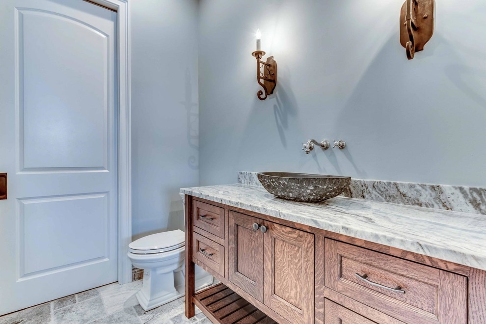 Mid-sized 3/4 bathroom in Cleveland with recessed-panel cabinets, dark wood cabinets, a two-piece toilet, blue walls, porcelain floors, a vessel sink and engineered quartz benchtops.