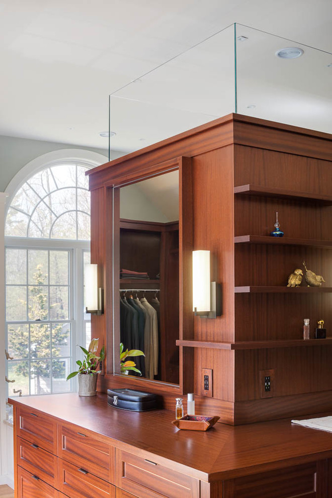Photo of a large transitional dressing room in Boston with flat-panel cabinets, dark wood cabinets and medium hardwood floors.